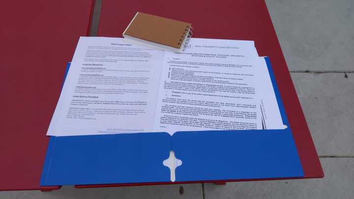 Blue folder opened on a red table. 